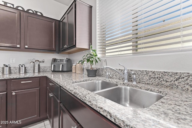 4741 E Fire Opal Ln, San Tan Valley, AZ 85143 - kitchen featuring a sink, dark brown cabinets, light tile patterned flooring, and light stone counters