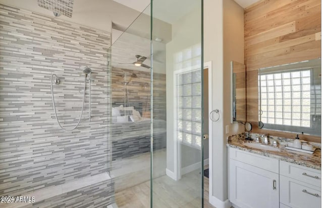 bathroom featuring a shower with door and vanity