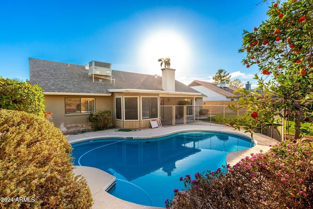 view of swimming pool featuring central AC and a sunroom