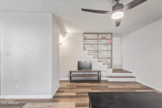 8538 E Portland St, Scottsdale, AZ 85257 - below grade area featuring wood finished floors, baseboards, a textured ceiling, ceiling fan, and stairs