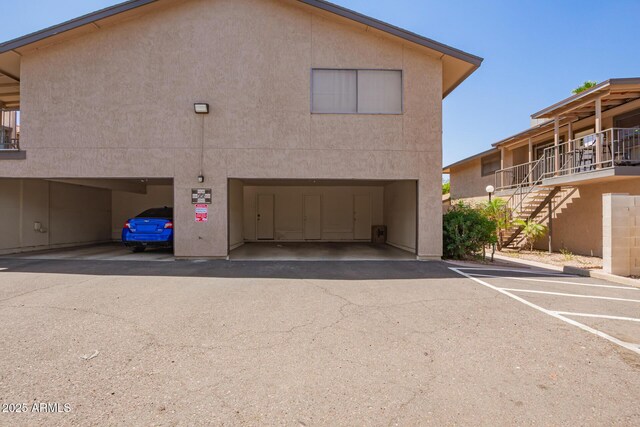 8538 E Portland St, Scottsdale, AZ 85257 - view of property exterior with stairway, stucco siding, and a parking lot