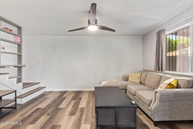 8538 E Portland St, Scottsdale, AZ 85257 - living area with a textured ceiling, ceiling fan, wood finished floors, stairs, and concrete block wall