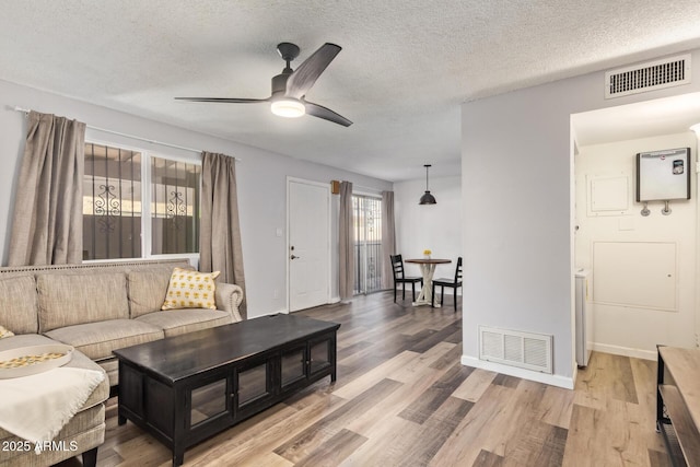 8538 E Portland St, Scottsdale, AZ 85257 - living room featuring ceiling fan, wood finished floors, a textured ceiling, and baseboards