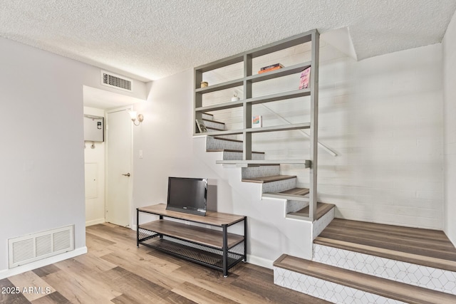 8538 E Portland St, Scottsdale, AZ 85257 - stairway featuring wood finished floors, a textured ceiling, and baseboards