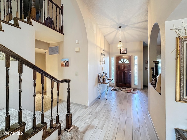 entrance foyer with light hardwood / wood-style flooring and a textured ceiling