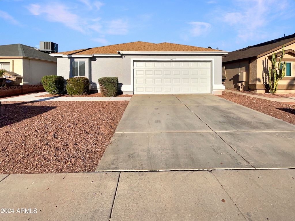 single story home featuring a garage and central AC