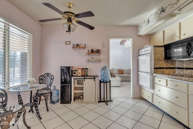 kitchen with ceiling fan, double oven, and light tile patterned floors