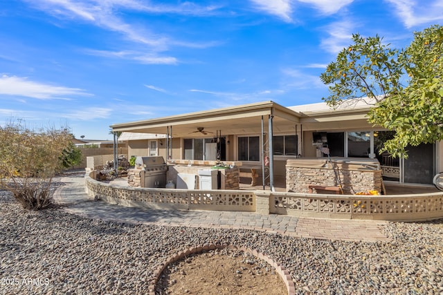 rear view of house featuring a patio, ceiling fan, and an outdoor kitchen