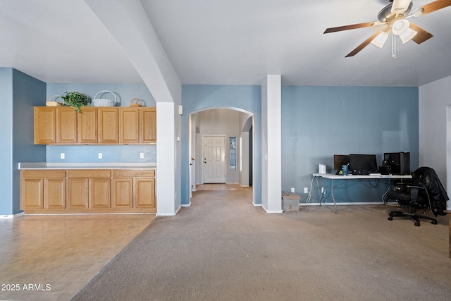 kitchen with light brown cabinetry, light carpet, and ceiling fan