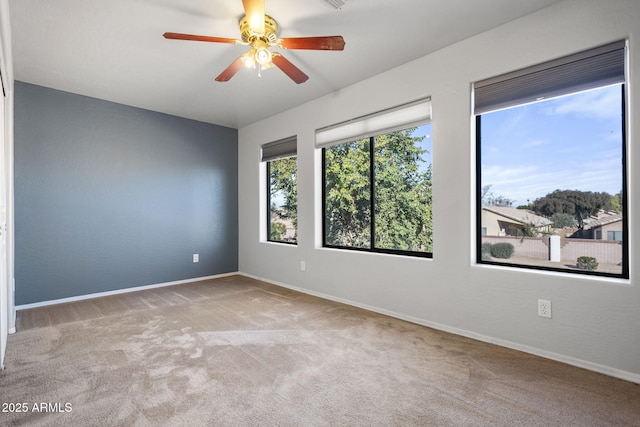 spare room with light colored carpet and ceiling fan