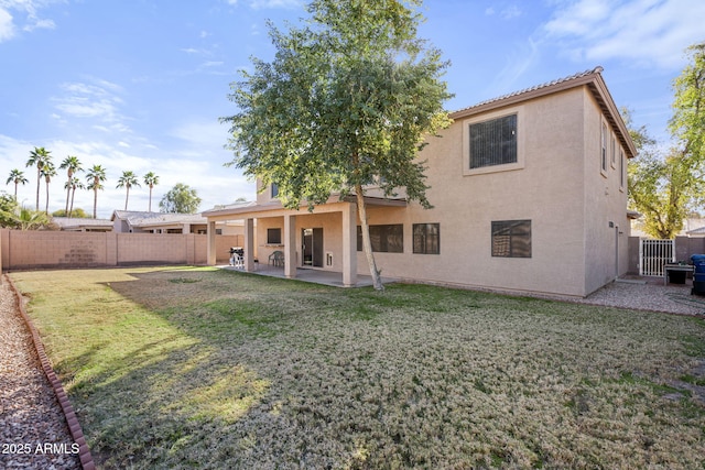 rear view of house with a lawn and a patio area