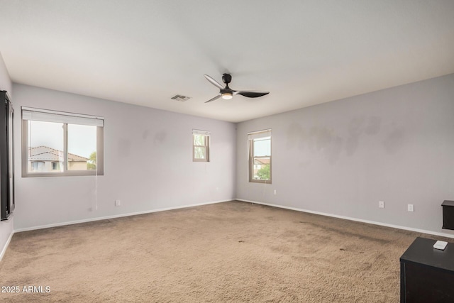 carpeted spare room featuring a ceiling fan, baseboards, and visible vents