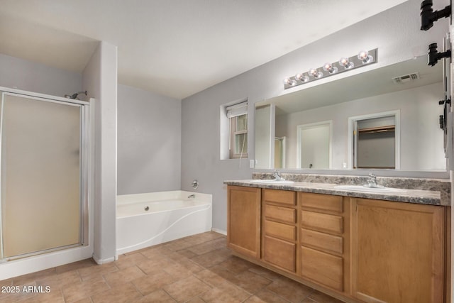 bathroom with a bath, a sink, and a shower stall