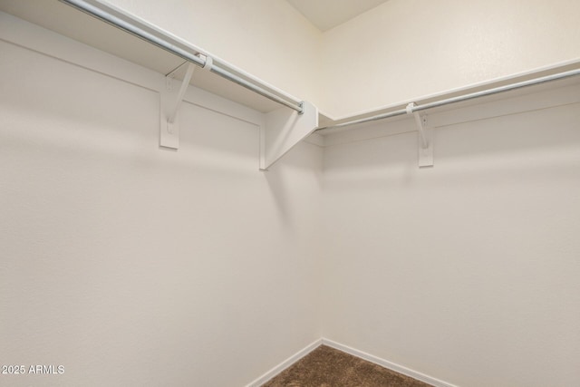 spacious closet featuring dark carpet