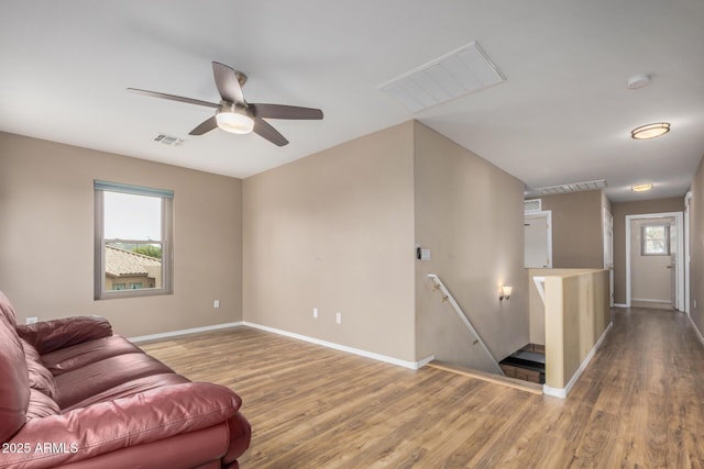 living area featuring plenty of natural light, visible vents, wood finished floors, and a ceiling fan