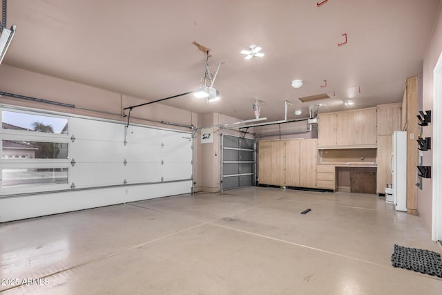 garage with freestanding refrigerator and a garage door opener