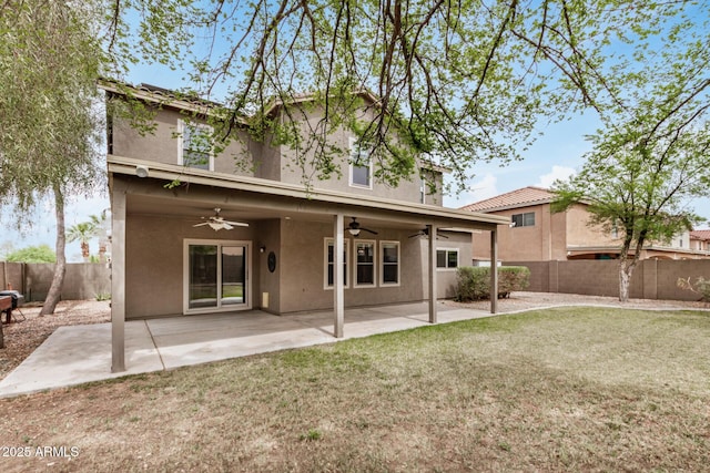 rear view of house with a fenced backyard, stucco siding, a patio, and a yard
