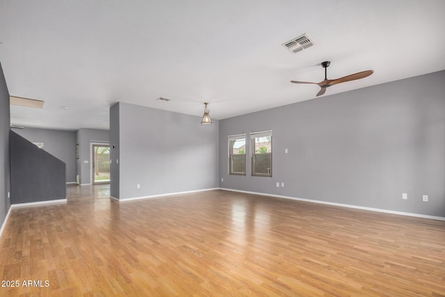 spare room with light wood-type flooring, baseboards, visible vents, and a ceiling fan