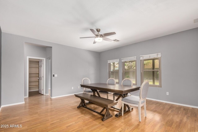 dining room featuring baseboards, light wood-style flooring, visible vents, and ceiling fan