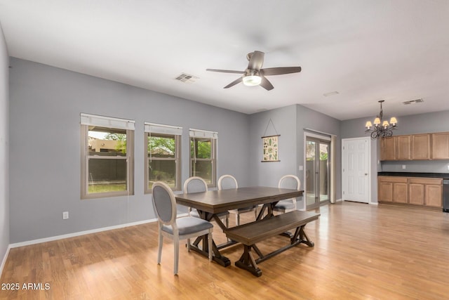 dining room with light wood finished floors, ceiling fan with notable chandelier, visible vents, and a healthy amount of sunlight