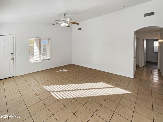 empty room featuring light tile patterned flooring, plenty of natural light, lofted ceiling, and ceiling fan