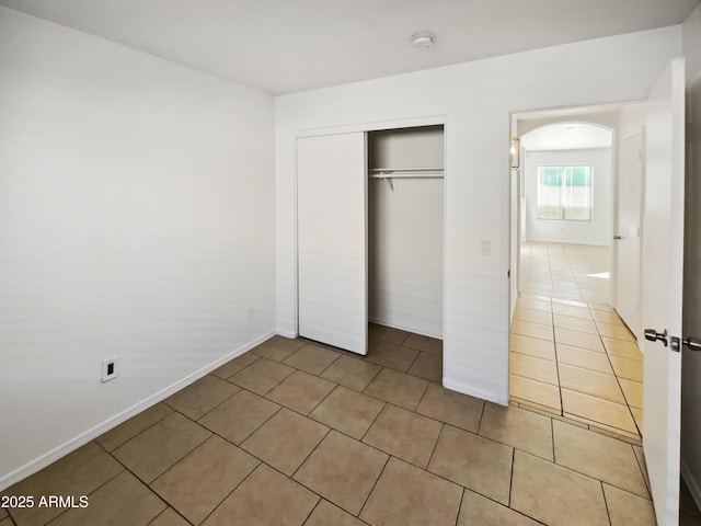 unfurnished bedroom featuring tile patterned floors and a closet