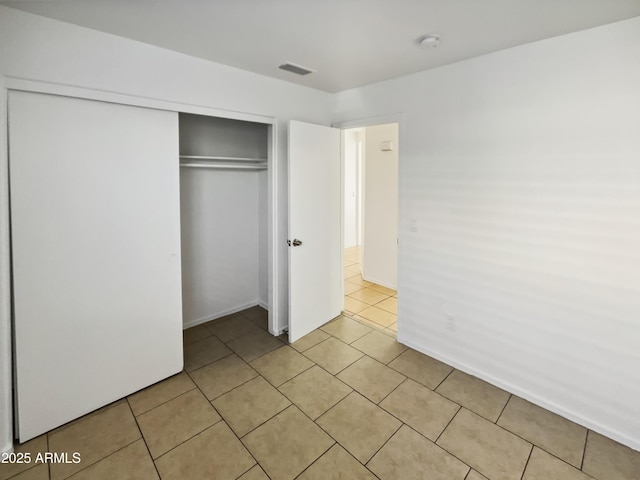 unfurnished bedroom with a closet and light tile patterned flooring