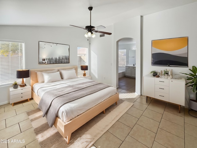 tiled bedroom with multiple windows, lofted ceiling, connected bathroom, and ceiling fan