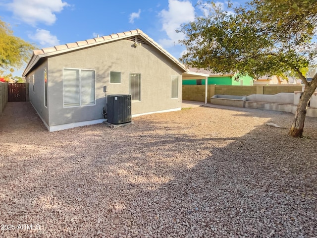 rear view of property featuring central AC