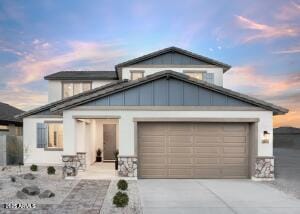 view of front of house featuring an attached garage, driveway, and stone siding