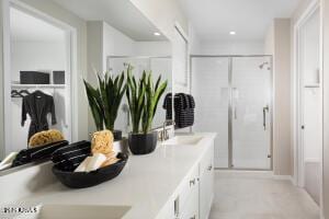 full bath with a stall shower, double vanity, and recessed lighting
