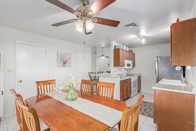 dining space with light tile patterned floors, ceiling fan, and sink