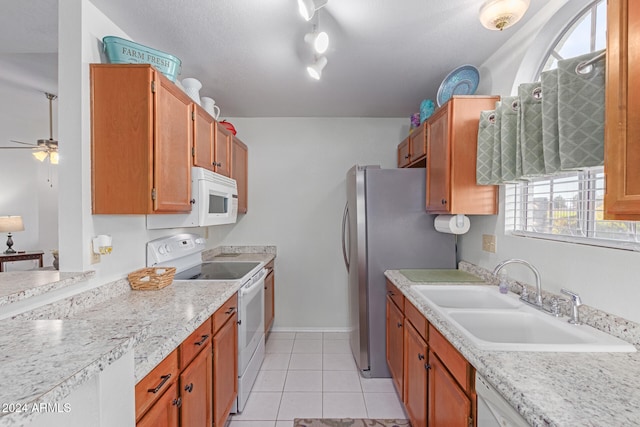 kitchen featuring ceiling fan, sink, a textured ceiling, white appliances, and light tile patterned floors