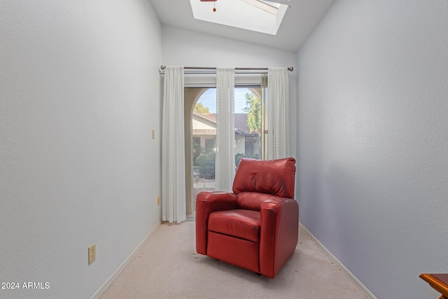 sitting room with light colored carpet and vaulted ceiling with skylight