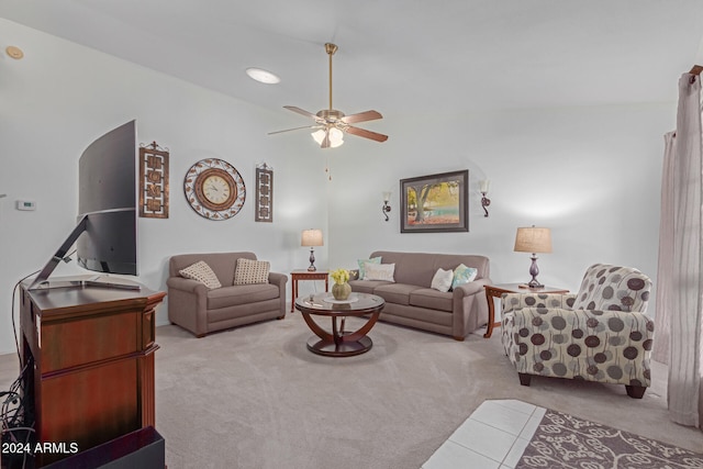 carpeted living room with ceiling fan and vaulted ceiling