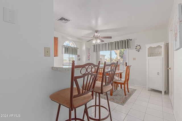 tiled dining space with ceiling fan