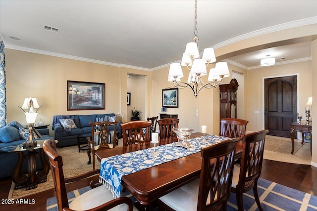 dining room with dark wood-style floors, visible vents, a chandelier, and crown molding