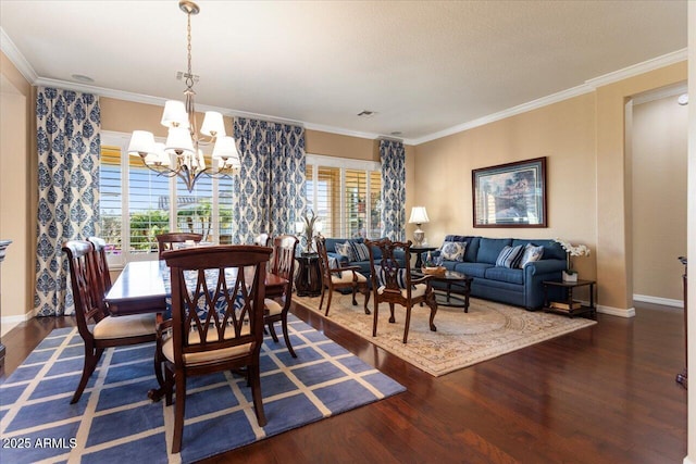 dining area with a chandelier, crown molding, baseboards, and wood finished floors