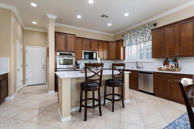 kitchen with visible vents, light countertops, ornamental molding, appliances with stainless steel finishes, and decorative backsplash