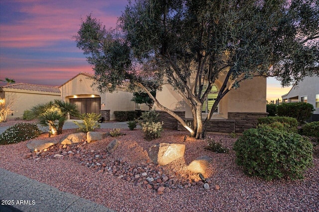 view of front of home featuring stone siding and stucco siding