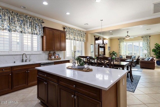 kitchen with light tile patterned floors, a sink, visible vents, and a healthy amount of sunlight