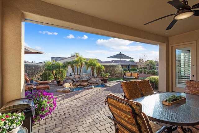 view of patio featuring outdoor dining space, grilling area, fence, and a ceiling fan