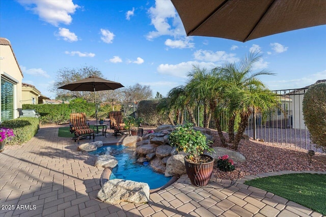 view of pool with a patio area and fence