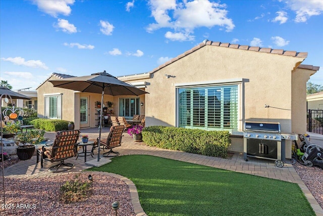 back of property with fence, a patio, a lawn, and stucco siding