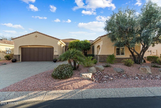 mediterranean / spanish home with stone siding, driveway, an attached garage, and stucco siding