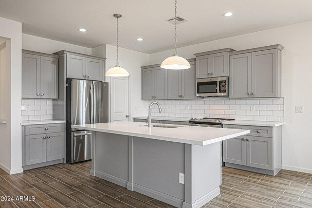 kitchen featuring dark hardwood / wood-style flooring, gray cabinetry, sink, and stainless steel appliances