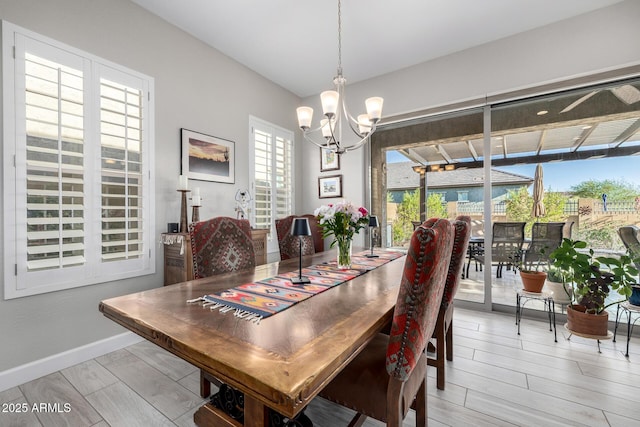 dining space featuring a chandelier, light wood-type flooring, and baseboards