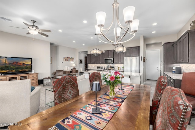 dining area with a chandelier, a ceiling fan, and recessed lighting