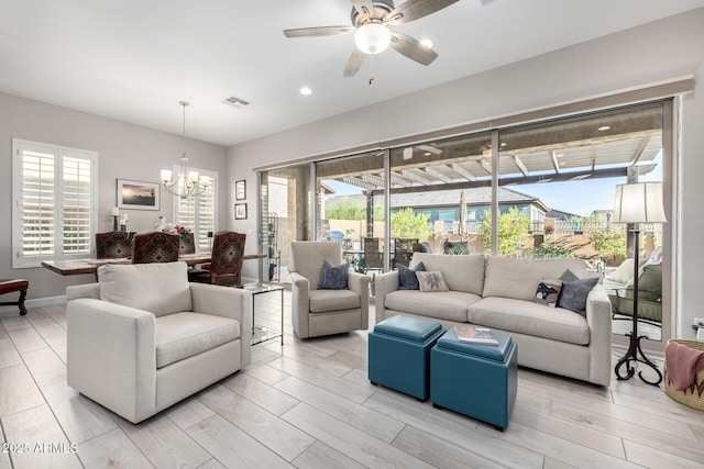 living area featuring a chandelier, ceiling fan, plenty of natural light, and recessed lighting