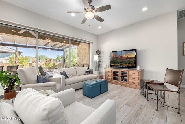 living room with light wood-type flooring, ceiling fan, and recessed lighting